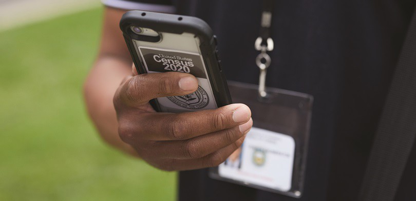 Close-up of a census taker's hand holding a mobile phone.