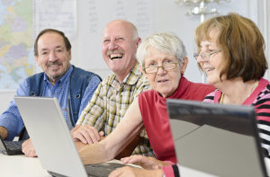 a group of workers gathered around a couple laptops