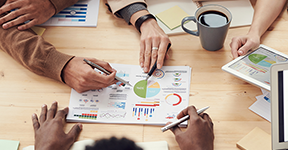 Image of business people reviewing charts and graphs at a table