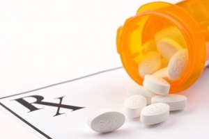 A picture of prescription pills spilling onto a prescription pad