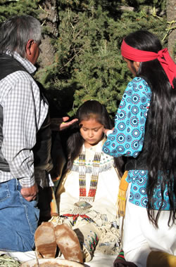 A young maiden being blessed by medicine man.
