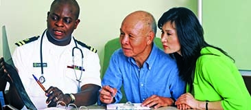 Doctor talking to an older man and his daughter