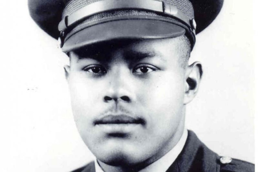 A man in an officer’s uniform looks at the camera.