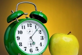 green alarm clock with an apple