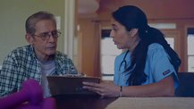 A medical professional shows a clipboard to a patient