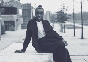 a young black woman sitting in the city