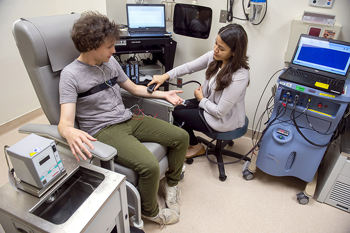 Senior research fellow Eleni Fragos conducts sensory testing with a volunteer in the NIH Clinical Center