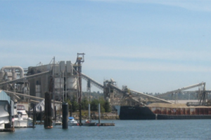 A boat navigates the Lower Duwamish River with industrial development on both sides of the river's banks.