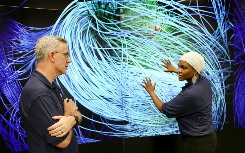 Scientists discuss a simulation in the EVEREST visualization theater of the Oak Ridge Leadership Computing Facility.