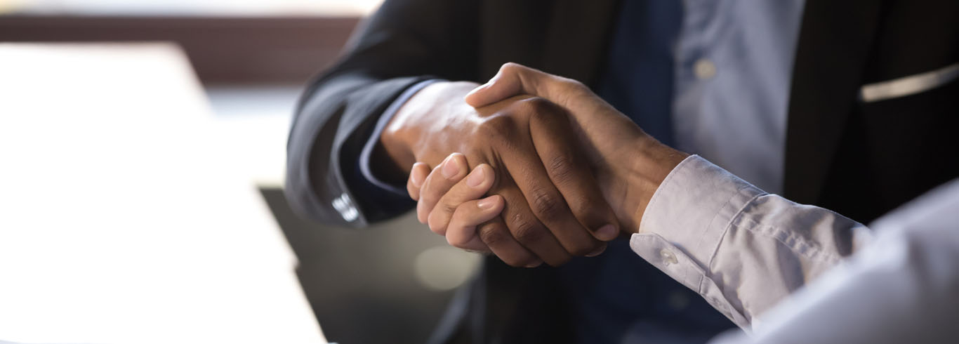 Two people shaking hands, focused in on hands. 