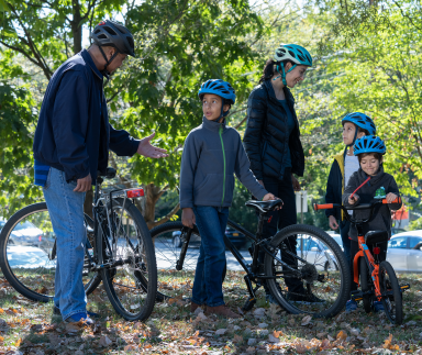 A family dons bicycle helmets.