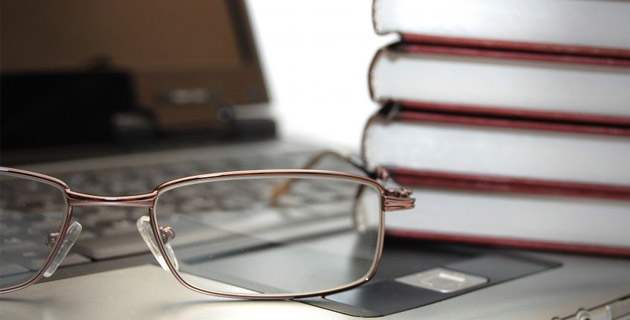 Photo of eyeglasses books laptop