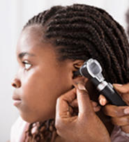 Young female patient having her ear examined with an otoscope.