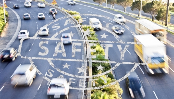 Traffic flowing on a busy highway with Safety decal superimposed on the road