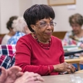 Older women sitting at tables, playing cards at a senior center.