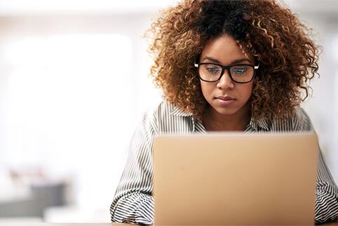 Woman looking down at laptop screen