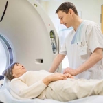 male medical technician with older woman about to get brain imaging test 