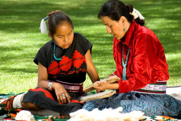 NIFA Funds Tribal Programs to Support Learning, Health & Opportunity.  Native American woman and girl sitting on the lawn; courtesy of Getty Images.