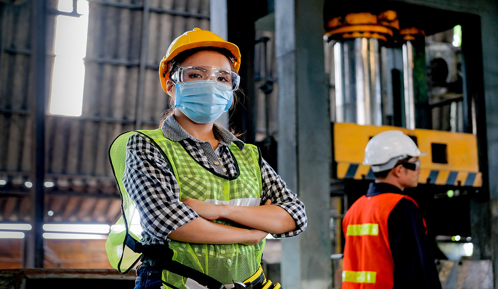 Factory woman worker or technician with hygienic mask stand with confident action with her co-worker as background | Photo Credit: iStockphoto-1214565315 | Copyright: Narongrit Sritana