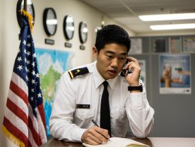 photo of a man in uniform making a phone call at an airport