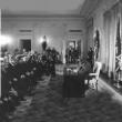 President Richard Nixon signing the National Cancer Act on December 23, 1971. This is a formal setting with a row of senators visible and some other officials and dignitaries.