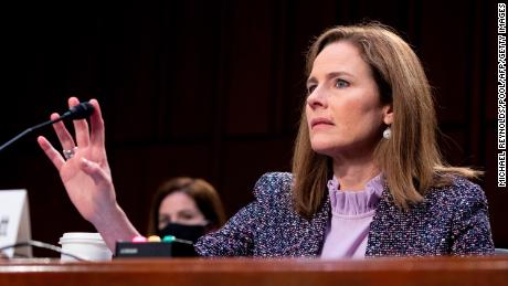 Supreme Court nominee Judge Amy Coney Barrett touches the mircophone during technical difficulties with the audio system during her confirmation hearing before the Senate Judiciary Committee on Capitol Hill on October 14, 2020 in Washington, DC. - After liberal icon Ruth Bader Ginsburg&#39;s death last month left the nine-member court with a vacancy, Trump has rushed to fill it at the height of his presidential election battle against Democrat Joe Biden. (Photo by MICHAEL REYNOLDS / POOL / AFP) (Photo by MICHAEL REYNOLDS/POOL/AFP via Getty Images)