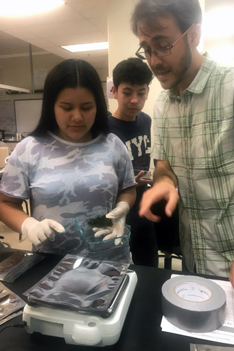 Chris Zuidema teaches students how to use lab equipment to analyze moss samples.