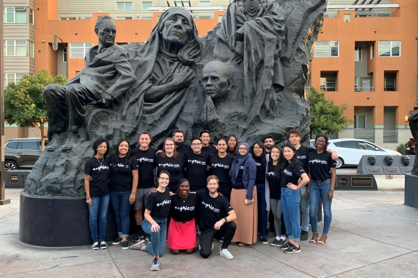 Emily Ward and her colleagues pose in front of a sculpture.