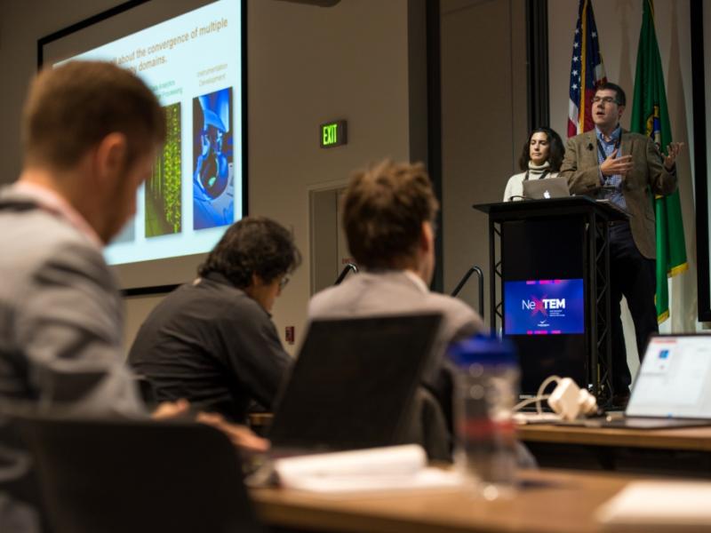 Researcher Steven Spurgeon stands at a podium to speak to a room full of scientists.