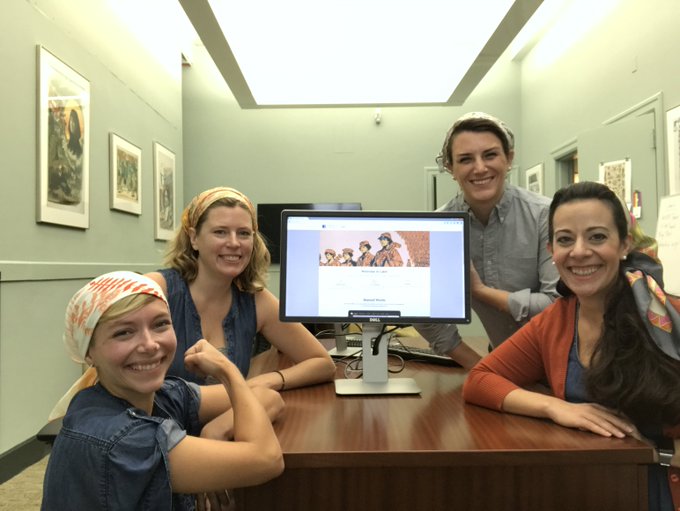 Four women of LC Labs team circled around a computer screen