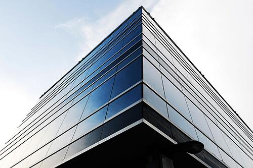 Office building with the photographer standing close to the bottom of the building while looking up at the sky.