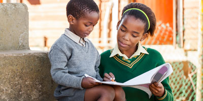 Older student reading younger student