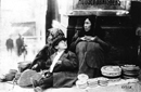 Two Indian women and a boy sit by their baskets on Second Avenue, outside the Frederick & Nelson department store in downtown Seattle, Washington. 1912