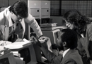 Three employees holding discussion at table