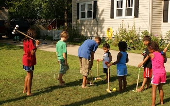 Children paying croquet on lawn