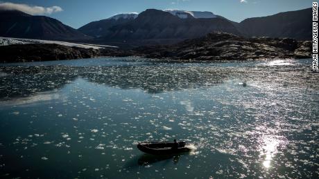 LONGYEARBYEN, NORWAY - AUGUST 25: Ice melts near  Nordenskjodbreen glacier as man past by with a boat on August 25, 2020 on the Norwegian Arctic Svalbard archipelago, Norway. Nordenskiöldbreen (Nordenskiöld Glacier) is a glacier in Spitsbergen, named after Finnish geologist Adolf Erik Nordenskiöld (Photo by Maja Hitij/Getty Images)