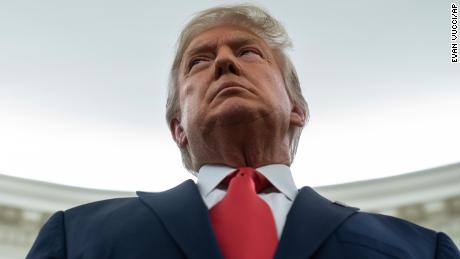 President Donald Trump listens during a ceremony to present the Presidential Medal of Freedom to former football coach Lou Holtz, in the Oval Office of the White House, Thursday, Dec. 3, 2020, in Washington. 