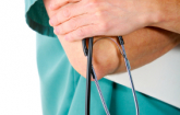 Arm of a person in green health uniform and stethoscope. (iStock)