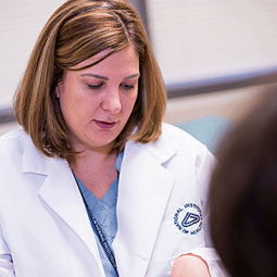 An NIH staff member gowes over a form with someone.