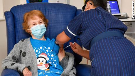 90 year old Margaret Keenan, the first patient in the UK to receive the Pfizer-BioNTech COVID-19 vaccine, administered by nurse May Parsons at University Hospital, Coventry, England, Tuesday Dec. 8, 2020. The United Kingdom, one of the countries hardest hit by the coronavirus, is beginning its vaccination campaign, a key step toward eventually ending the pandemic. (Jacob King/Pool via AP)