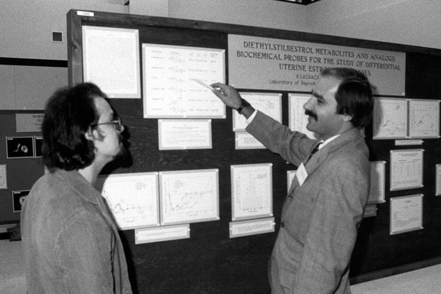 Ken Korach, Chief of the Reproductive and Developmental Biology Laboratory discusses his scientific poster with Don Harvan. mid 1980s