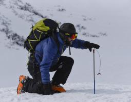 Ryan Crumley measures snow depth in the White Mountains of New Hampshire.