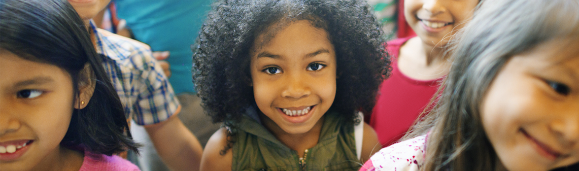 Image of a smiling girl in a crowd of happy children