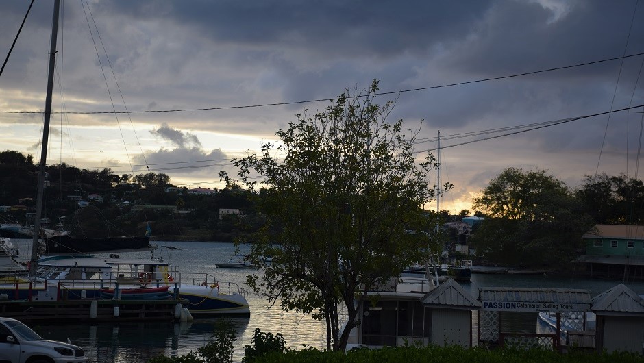 The sun sets over a bay by an idyllic coastal town in the Eastern Caribbean.