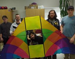 College students pose with a big kite.