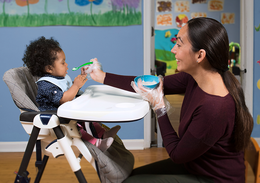 mother spoon-feeding child