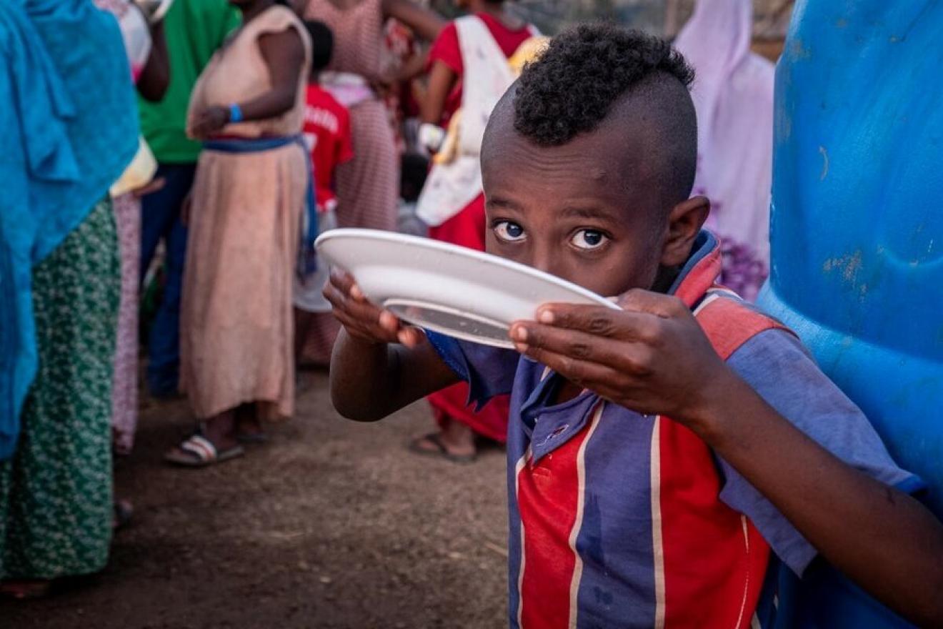 A boy eating from plate.