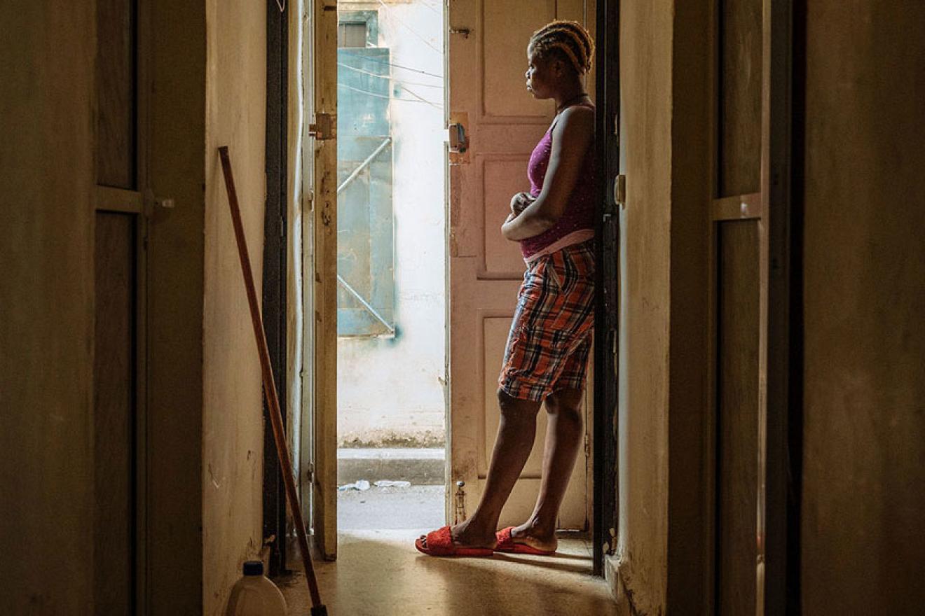 migrant worker standing in doorway