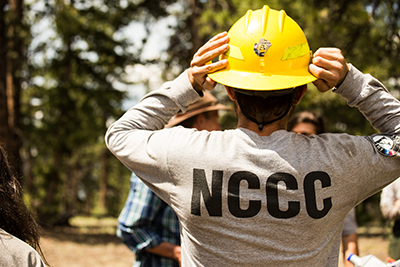 AmeriCorps members outside in yellow field uniforms