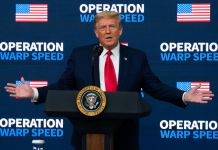 Donald Trump speaking on podium with arms open in front of an Operation Warp Speed background (© Evan Vucci/AP Images)